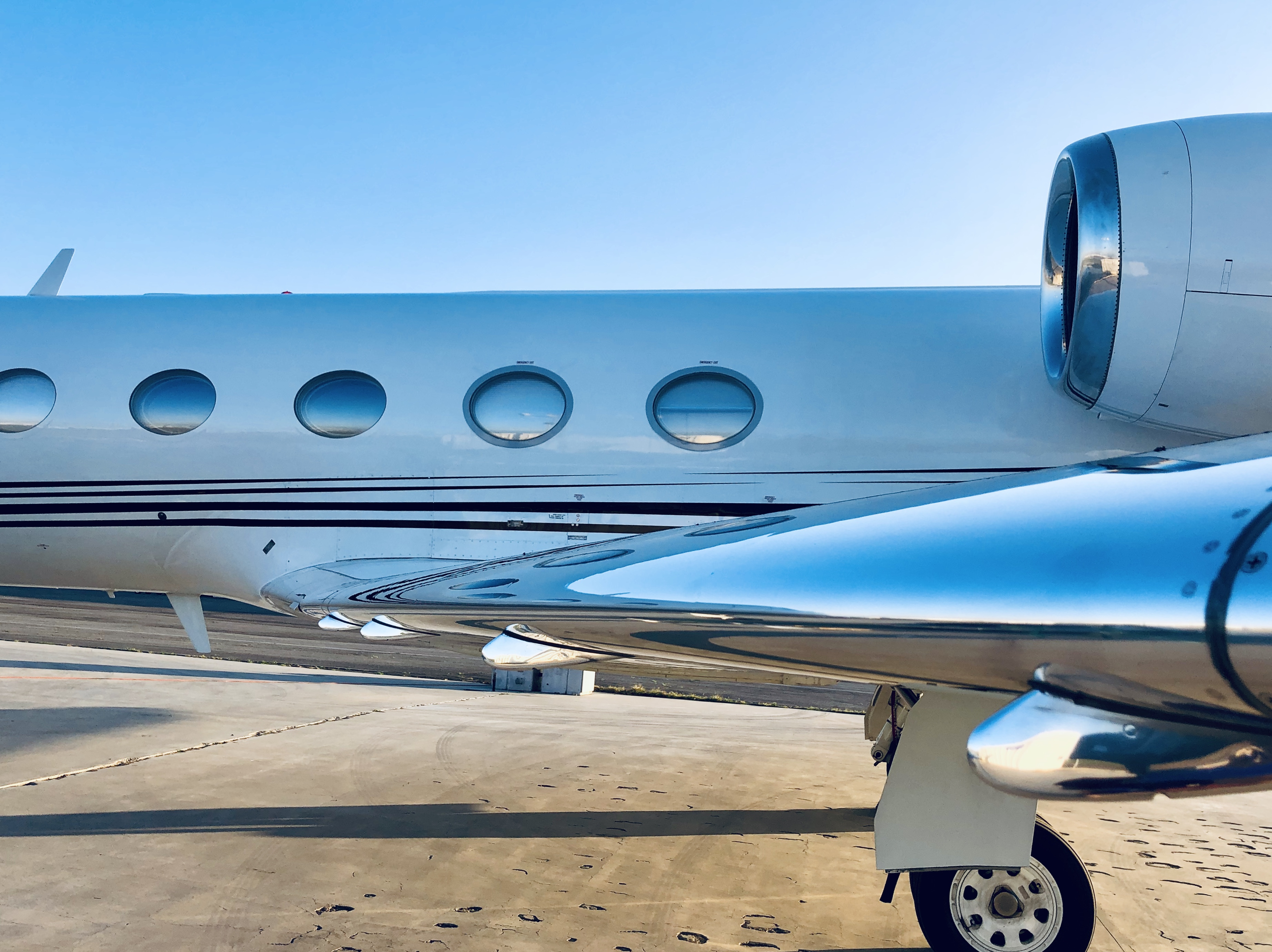 Mirror-polished aircraft brightwork on a private jet wing leading edge and engine nacelle — polished with Fly Shiny aviation metal polish